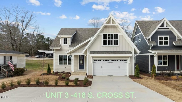 view of front facade with an attached garage, a shingled roof, board and batten siding, and concrete driveway