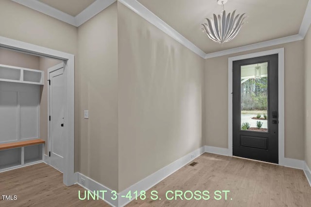 entryway with baseboards, ornamental molding, and wood finished floors