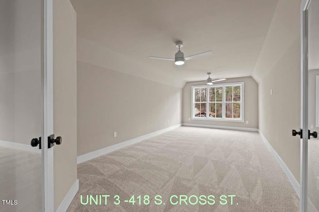 carpeted empty room with french doors, baseboards, a ceiling fan, and lofted ceiling