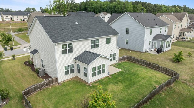 back of property with central AC, roof with shingles, a patio, and a residential view