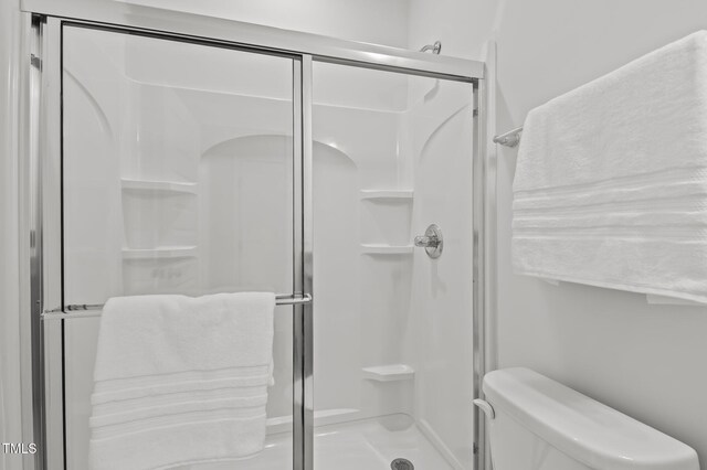 bathroom featuring a shower stall and toilet