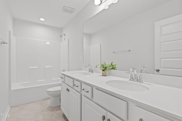 bathroom featuring toilet, tile patterned flooring, double vanity, and bathtub / shower combination
