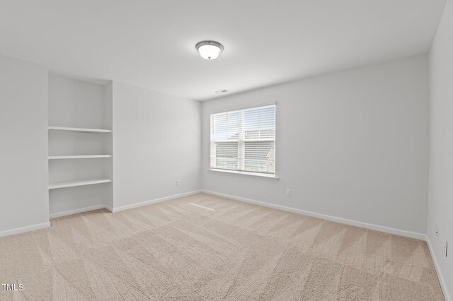 carpeted spare room featuring baseboards