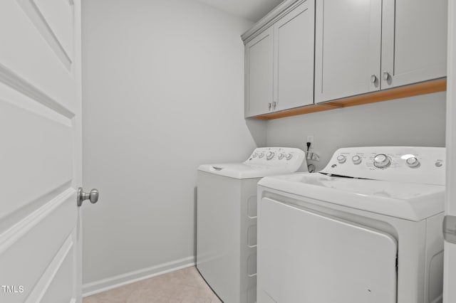 laundry room with cabinet space, washing machine and clothes dryer, baseboards, and light tile patterned floors