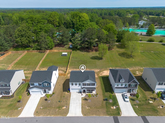 birds eye view of property featuring a wooded view and a residential view