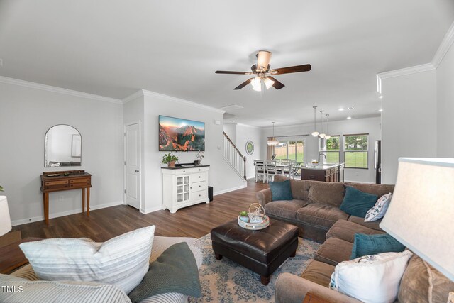 living room featuring dark wood finished floors, baseboards, ceiling fan, and crown molding