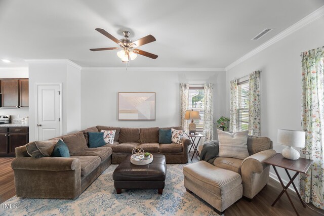 living area featuring visible vents, wood finished floors, ceiling fan, and ornamental molding
