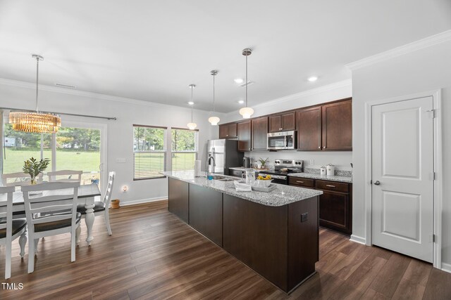kitchen with an island with sink, an inviting chandelier, stainless steel appliances, dark brown cabinets, and a sink