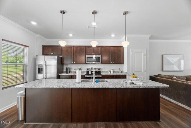 kitchen with an island with sink, appliances with stainless steel finishes, dark brown cabinets, a sink, and crown molding