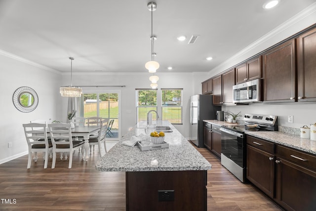kitchen featuring a sink, appliances with stainless steel finishes, visible vents, dark brown cabinetry, and dark wood finished floors