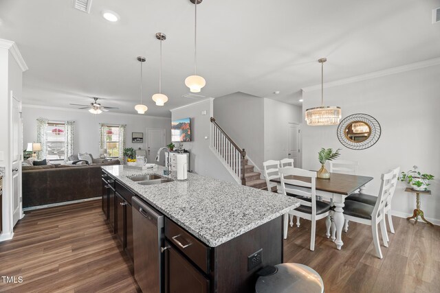 kitchen featuring a sink, wood finished floors, stainless steel dishwasher, open floor plan, and ceiling fan with notable chandelier