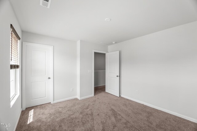 unfurnished bedroom featuring visible vents, baseboards, and carpet floors