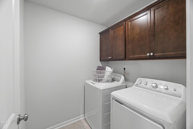 washroom with baseboards, cabinet space, light tile patterned flooring, and washing machine and clothes dryer