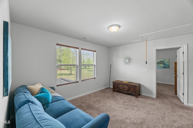 living room with attic access, visible vents, carpet, and baseboards