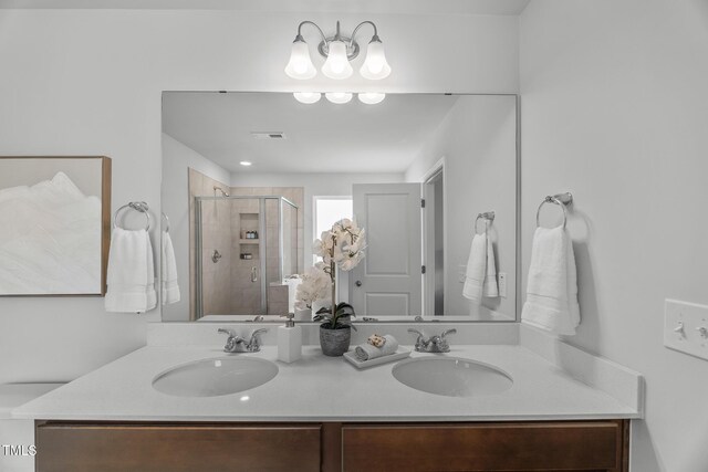 full bath with double vanity, visible vents, a stall shower, and a sink