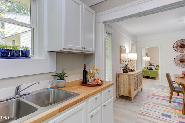 919 Orient St, Durham, NC 27701 - kitchen with white cabinets, a sink, and light wood-type flooring