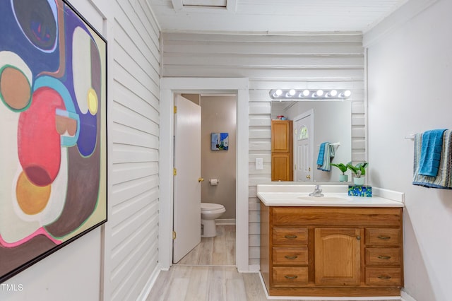 919 Orient St, Durham, NC 27701 - bathroom with toilet, vanity, wood finished floors, and wooden walls
