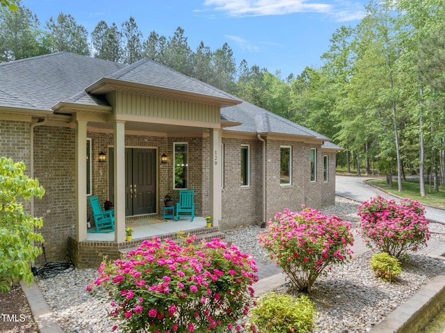 120 Wood Lake Dr, Fuquay Varina, NC 27526 - exterior space featuring a porch, a shingled roof, and brick siding