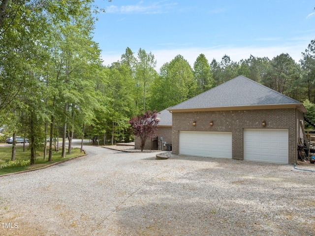 120 Wood Lake Dr, Fuquay Varina, NC 27526 - view of home's exterior featuring brick siding, gravel driveway, and roof with shingles