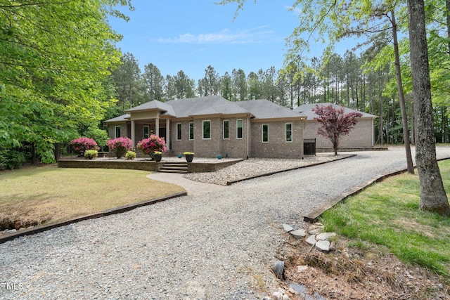 120 Wood Lake Dr, Fuquay Varina, NC 27526 - view of front facade with a front yard, gravel driveway, and brick siding