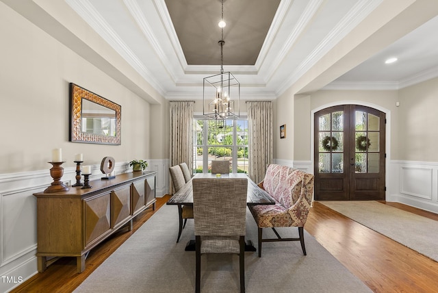dining space with a healthy amount of sunlight, a raised ceiling, and dark wood-type flooring