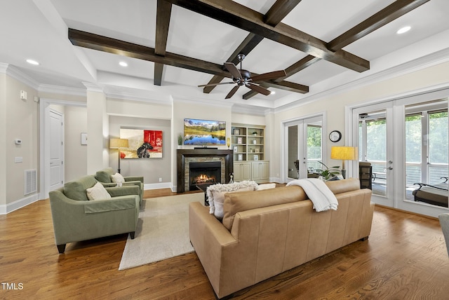 living room featuring beam ceiling, wood finished floors, a fireplace, french doors, and coffered ceiling