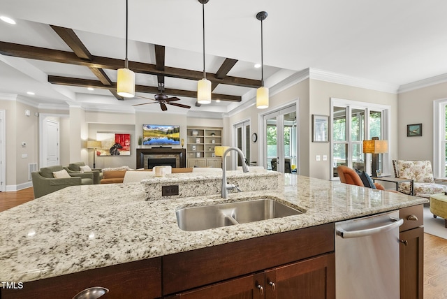 kitchen with a sink, stainless steel dishwasher, light wood-type flooring, and open floor plan