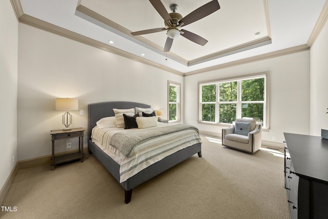 bedroom featuring crown molding, a tray ceiling, and light colored carpet