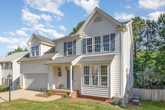traditional home featuring a garage, central AC, fence, a shingled roof, and driveway