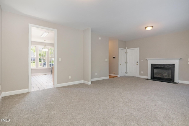 unfurnished living room with a fireplace with flush hearth, carpet floors, and baseboards