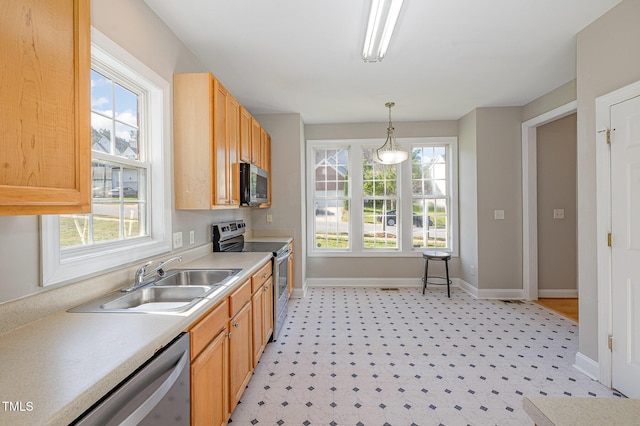kitchen with a sink, baseboards, stainless steel appliances, and a healthy amount of sunlight