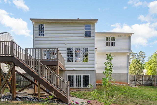 back of property featuring a yard, a deck, fence, and stairs