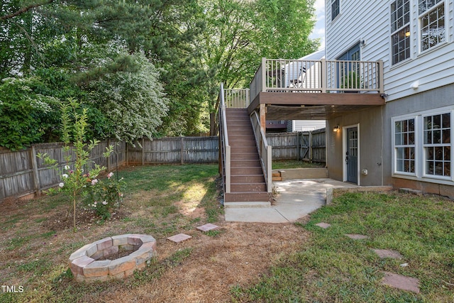 view of yard with a fenced backyard, an outdoor fire pit, stairway, and a deck