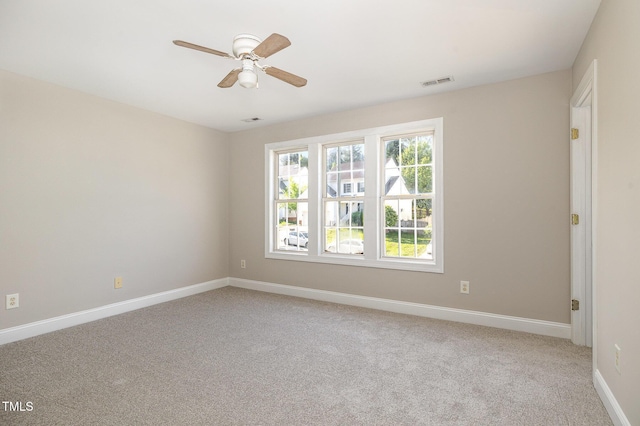 unfurnished room with visible vents, baseboards, ceiling fan, and light carpet