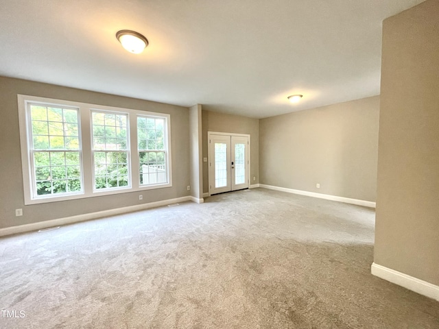 empty room with carpet flooring, baseboards, and visible vents