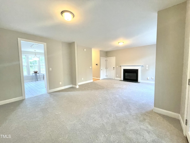 unfurnished living room with a fireplace with flush hearth, baseboards, and carpet flooring