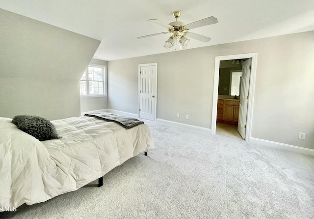 bedroom featuring baseboards, ensuite bathroom, ceiling fan, and light colored carpet