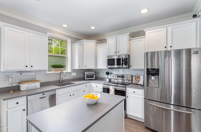 1209 Shasta Daisy Dr, Wake Forest, NC 27587 - kitchen with stainless steel appliances, a sink, white cabinets, decorative backsplash, and a kitchen island