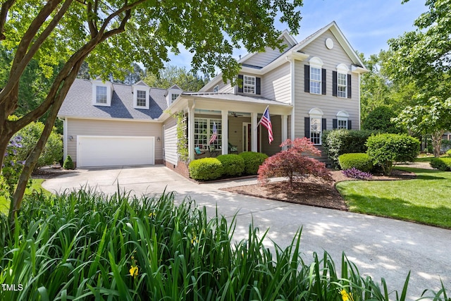 traditional home with a porch, a garage, and driveway