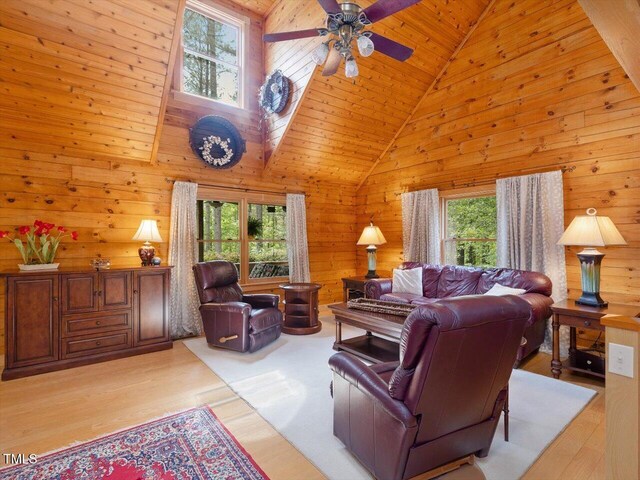 3009 Pleasant Hill Church Rd, Siler City, NC 27344 - living room featuring healthy amount of natural light, high vaulted ceiling, a ceiling fan, wood walls, and light wood-style floors