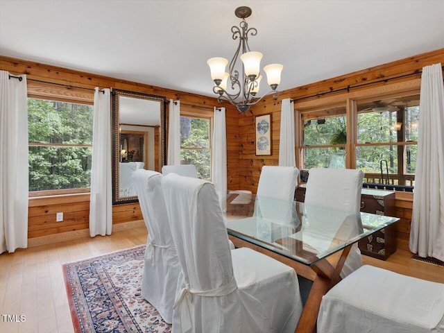 3009 Pleasant Hill Church Rd, Siler City, NC 27344 - dining room with a chandelier, light wood-style flooring, and wooden walls