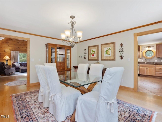 3009 Pleasant Hill Church Rd, Siler City, NC 27344 - dining room featuring a chandelier, light wood-style flooring, crown molding, and baseboards