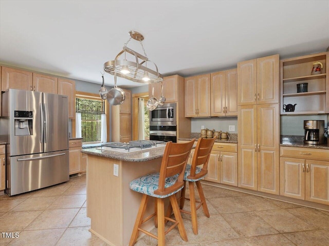 3009 Pleasant Hill Church Rd, Siler City, NC 27344 - kitchen with stainless steel appliances, light brown cabinetry, a center island, dark stone countertops, and a kitchen breakfast bar