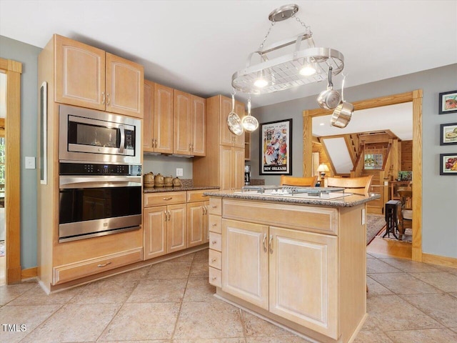 3009 Pleasant Hill Church Rd, Siler City, NC 27344 - kitchen featuring stainless steel appliances, light brown cabinets, a center island, light stone countertops, and baseboards
