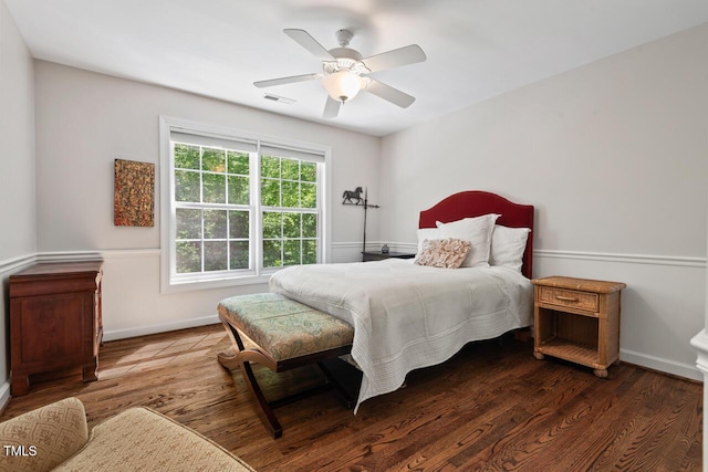 bedroom featuring a ceiling fan, baseboards, and wood finished floors