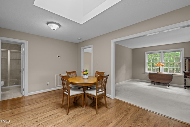 dining room with baseboards and light wood finished floors