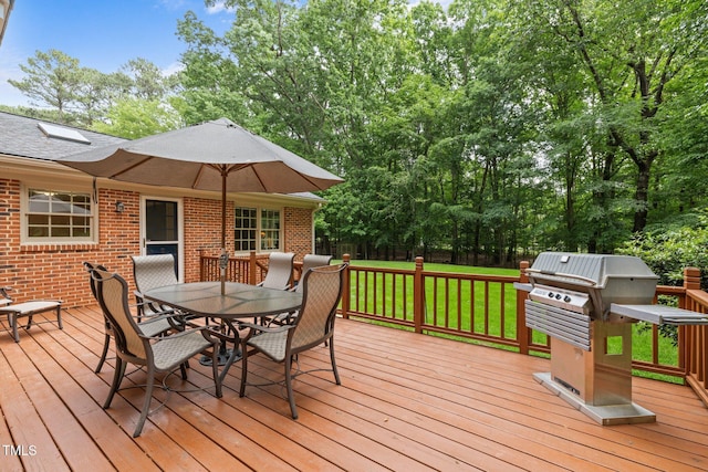 wooden terrace with outdoor dining area, a lawn, and a grill