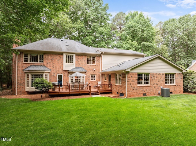 rear view of house featuring a deck, a lawn, brick siding, and central AC unit