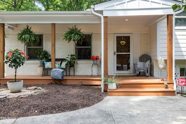 property entrance with brick siding and covered porch