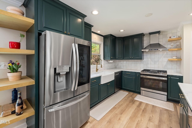 kitchen featuring open shelves, a sink, stainless steel appliances, light countertops, and wall chimney exhaust hood